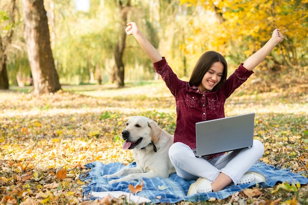 Happy woman with her dog in the park