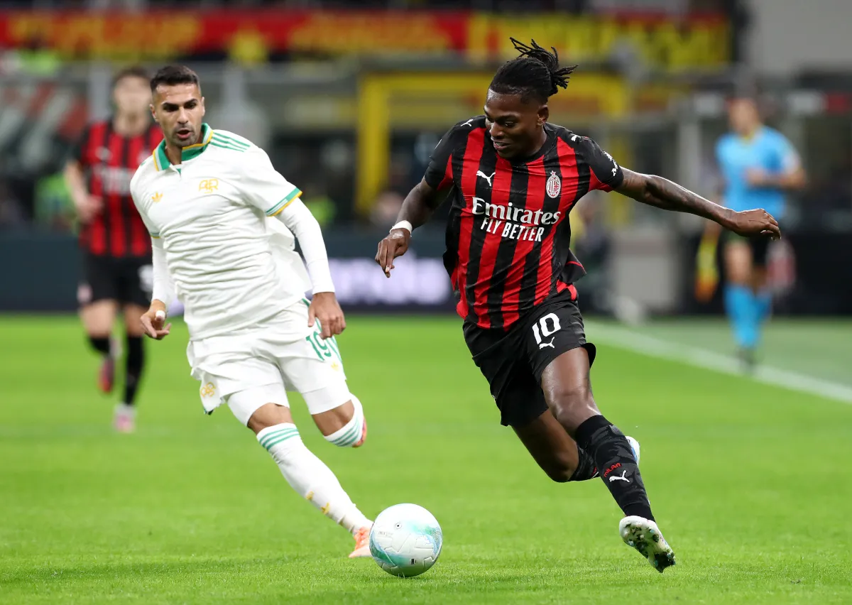 Rafael Leao của AC Milan chạy với quả bóng dưới sự đe dọa của Zeki Celik của AS Roma tại Sân vận động Giuseppe Meazza